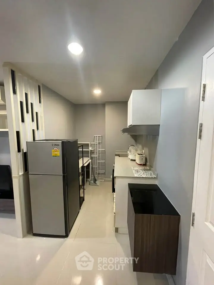 Modern kitchen with sleek cabinetry and stainless steel appliances in a contemporary apartment.
