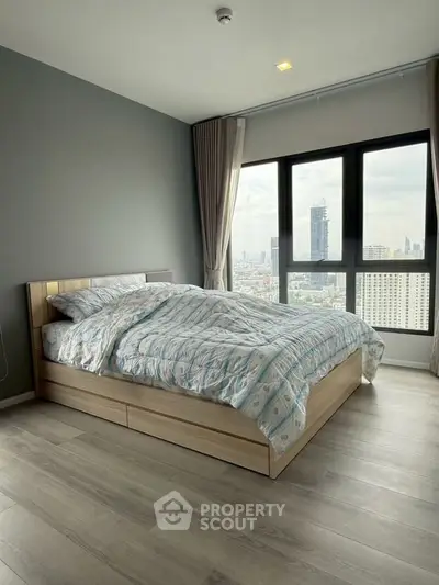 Modern bedroom with city view, featuring large windows and stylish decor in a high-rise apartment.
