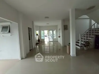Spacious open-plan living area with modern staircase and large windows