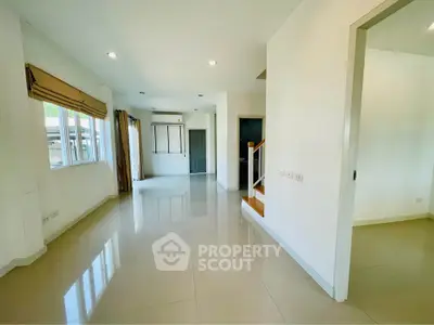 Spacious modern living room with large windows and glossy tile flooring