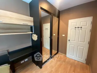 Modern bedroom with mirrored wardrobe and wooden flooring in cozy apartment