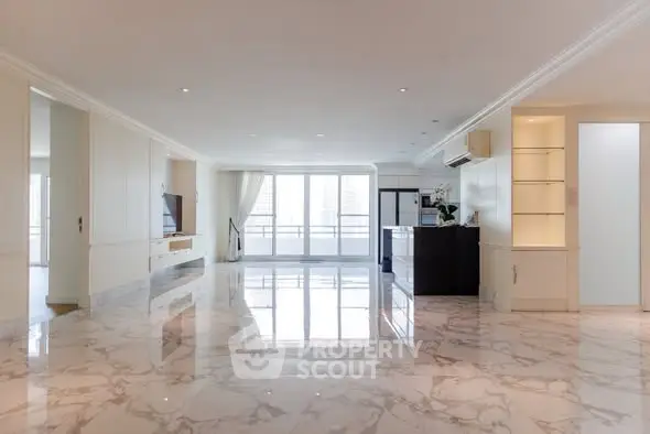Spacious modern living room with marble flooring and large windows offering natural light.