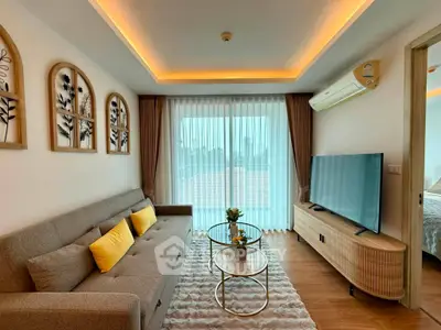 Modern living room with stylish decor, large TV, and cozy seating area, perfect for relaxation and entertainment.