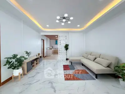 Modern living room with stylish lighting and open view to kitchen
