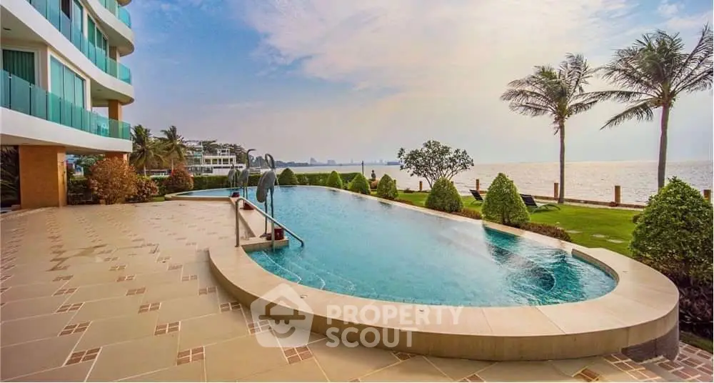 Luxurious beachfront pool with stunning ocean view and lush landscaping.