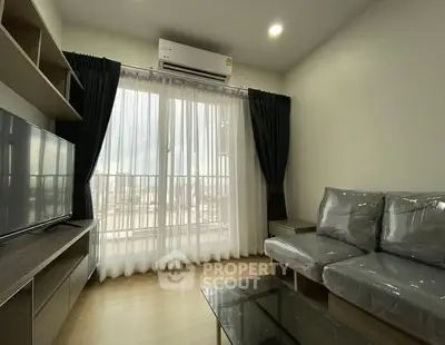 Modern living room with sleek furniture and large window for natural light.