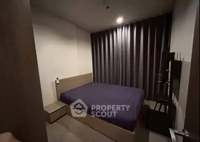 Cozy modern bedroom with dark curtains and minimalist furniture, perfect for restful nights.