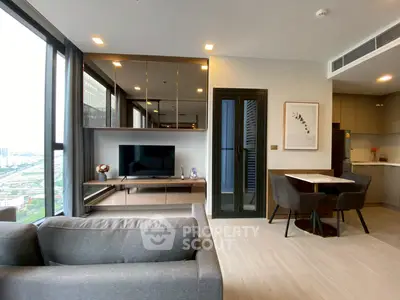 Modern living room with sleek furniture and open kitchen layout in a high-rise apartment.
