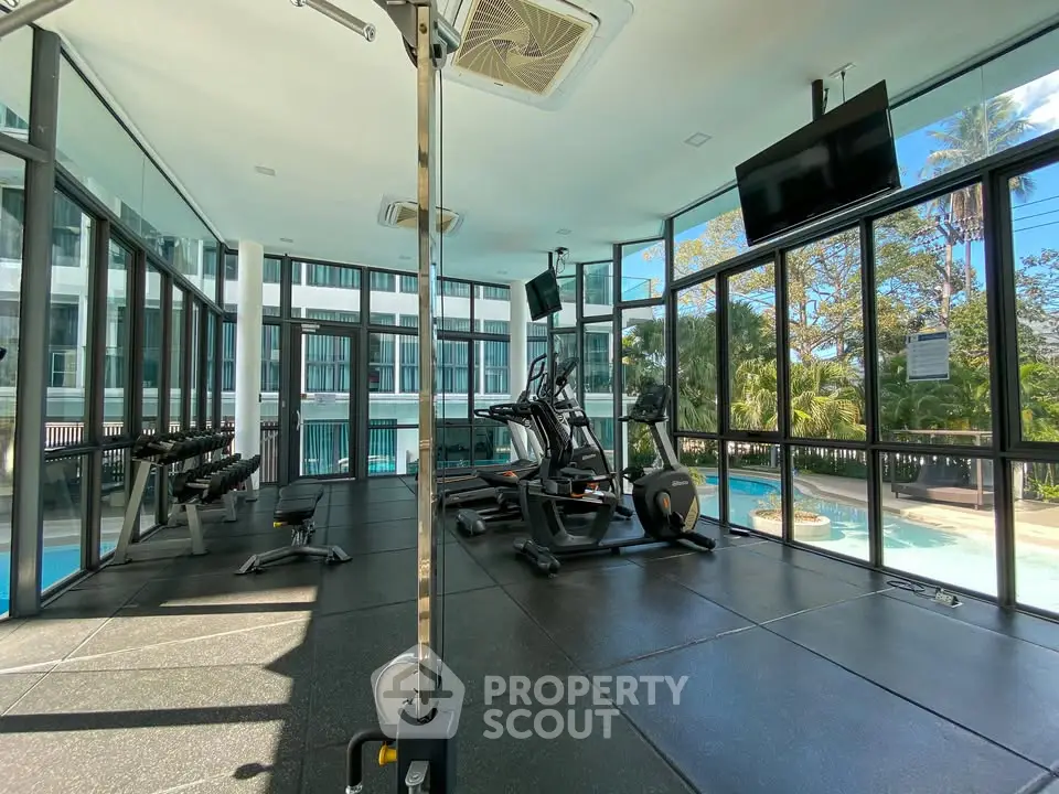 Modern gym with pool view in luxury apartment complex