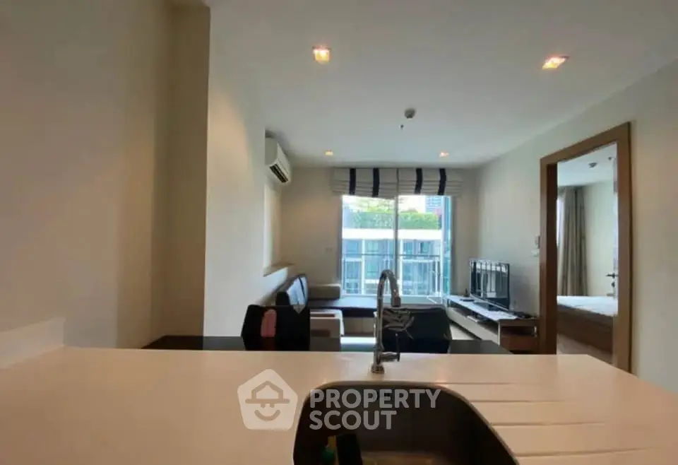 Modern open-layout living room with kitchen island and large window view