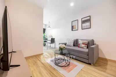 Modern living room with stylish decor and open layout, featuring a cozy sofa and sleek TV setup.