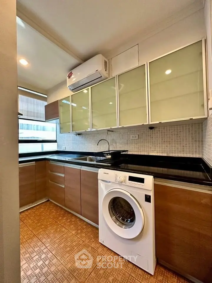 Modern kitchen with sleek cabinets and built-in washing machine
