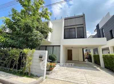 Modern two-story house with sleek design and spacious driveway in a serene neighborhood.