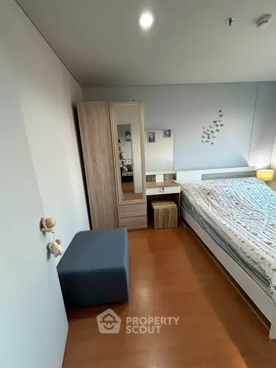 Cozy bedroom with modern furniture and wooden flooring, perfect for relaxation and comfort.