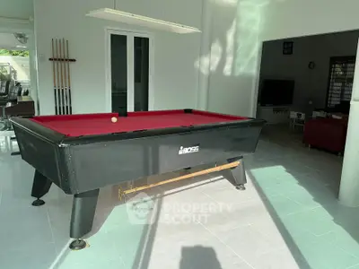 Spacious living area with pool table and modern decor, perfect for entertainment and relaxation.
