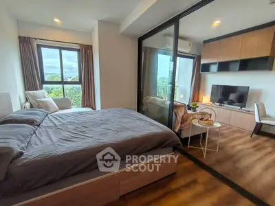 Modern bedroom with large window and cozy living area in stylish apartment