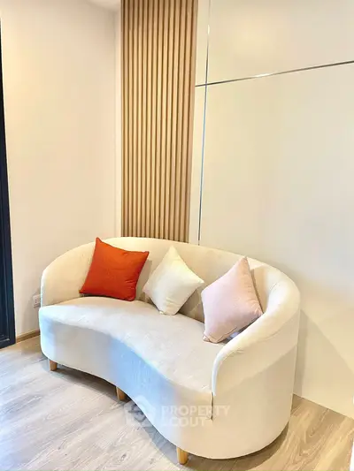 Stylish modern living room with elegant curved sofa and cozy cushions, perfect for relaxation.