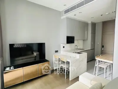 Modern open-layout kitchen and living area with sleek design and neutral tones.