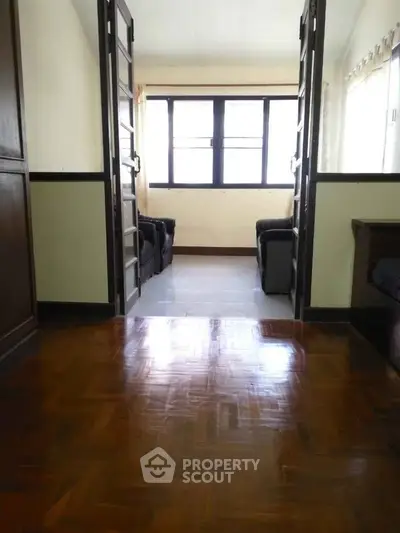 Spacious living room with wooden flooring and natural light