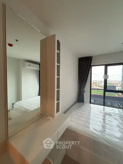 Modern bedroom with large window and city view, featuring a comfortable bed and sleek design.