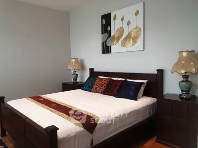 Elegant bedroom with stylish decor and cozy ambiance, featuring a comfortable bed and artistic wall art.