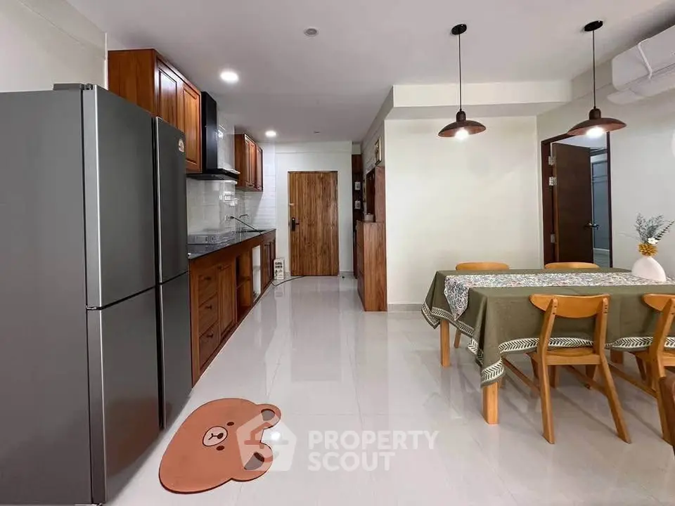 Spacious kitchen and dining area with modern appliances and stylish wooden furniture.