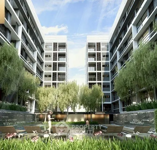 Modern apartment complex with lush greenery and outdoor seating area.