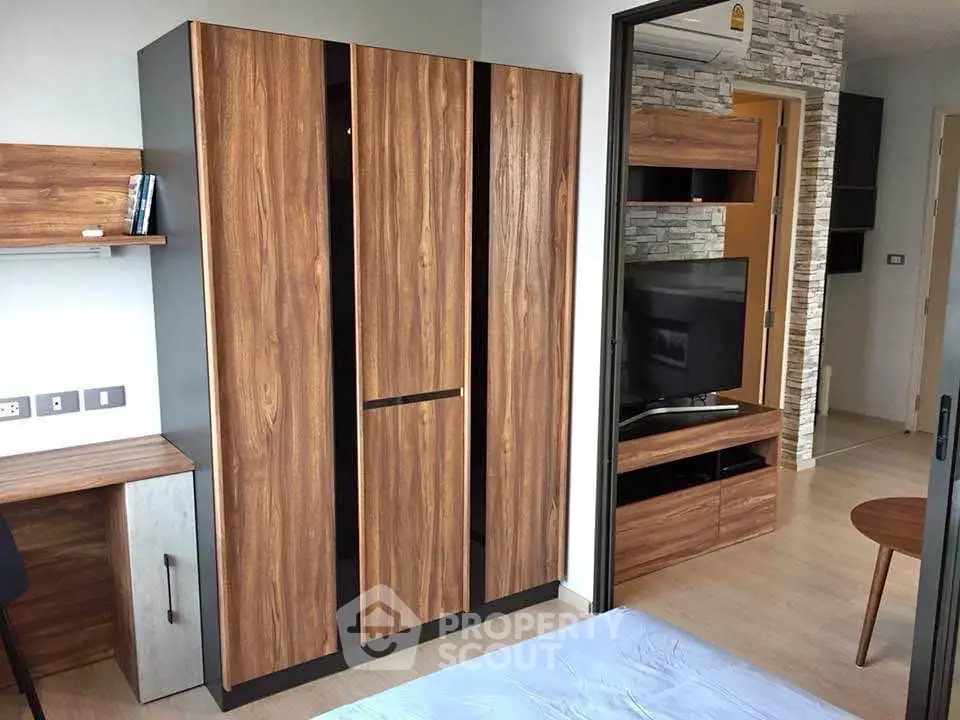 Modern bedroom with wooden wardrobe and TV unit, stylish interior design.