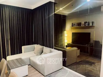 Modern living room with sleek design, featuring a cozy sectional sofa, mirrored wall, and elegant decor.