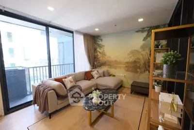 Stylish living room with scenic mural and modern decor, opening to a balcony.
