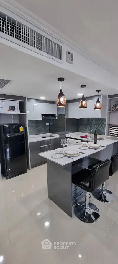 Modern kitchen with sleek design, featuring an island and stylish pendant lighting.