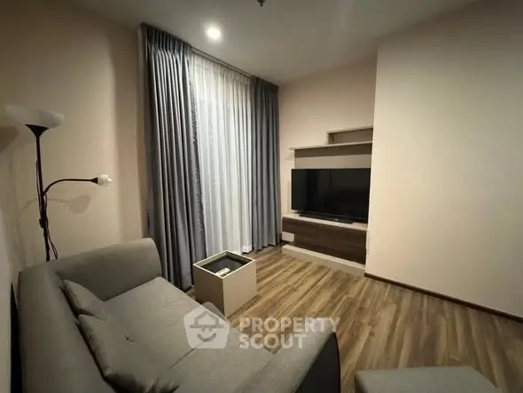 Cozy living room with modern decor and large TV, perfect for relaxation.