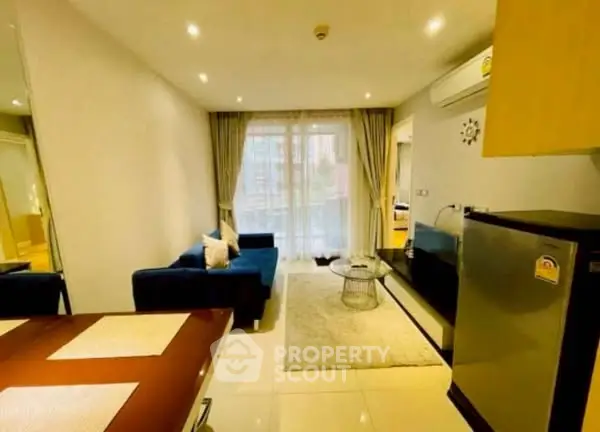Modern living room with cozy sofa, stylish decor, and natural light from large windows.