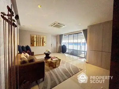 Spacious living room with modern furnishings, ample natural light, and a large balcony offering an inviting atmosphere for relaxation and entertainment.