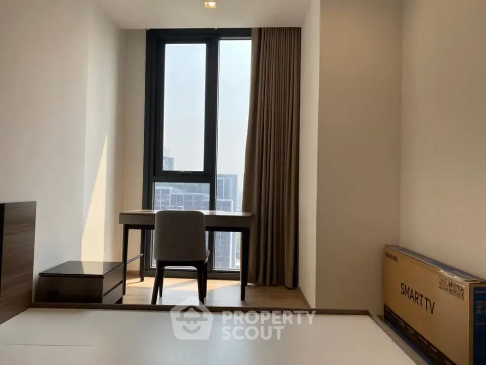 Modern study room with large window and smart TV box, perfect for productivity and relaxation.