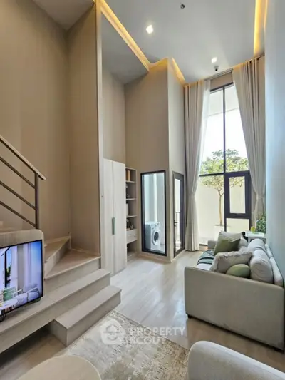 Modern duplex living room with high ceilings and large windows