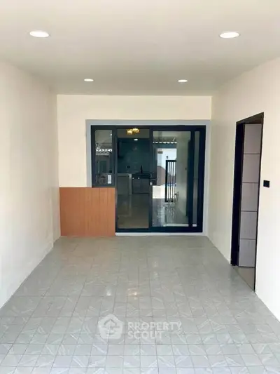 Spacious interior with tiled flooring and modern lighting, ideal for versatile living arrangements.