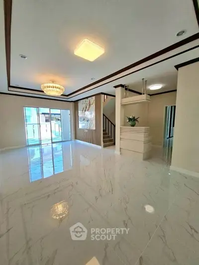 Spacious modern living room with elegant chandelier and marble flooring