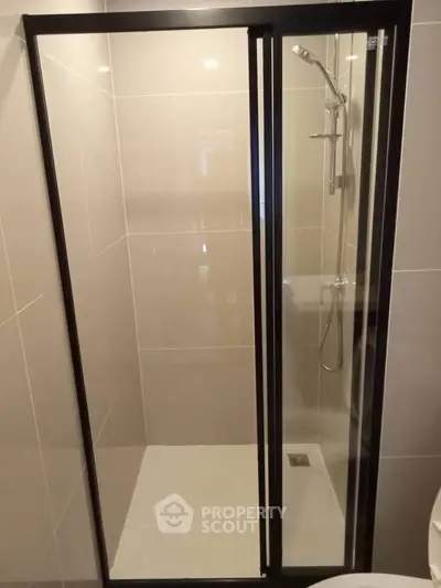 Modern bathroom with sleek glass shower enclosure and contemporary fixtures.