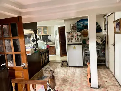 Charming kitchen with open layout and vintage decor, featuring wooden accents and tiled flooring.