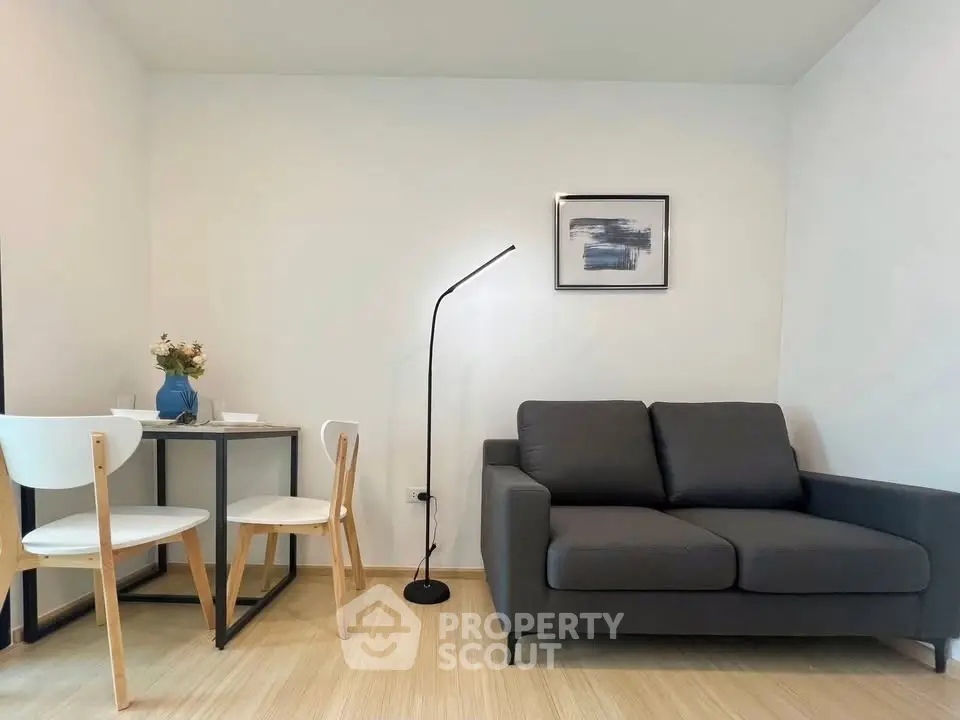 Modern living room with sleek sofa and dining area, perfect for cozy urban living.