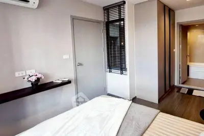 Modern bedroom with sleek design and ensuite bathroom in contemporary apartment.