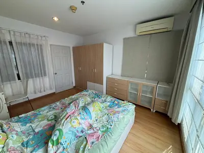 Spacious bedroom with natural light and modern furnishings