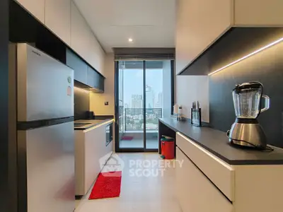 Modern kitchen with sleek design and city view from balcony, featuring stainless steel appliances and stylish cabinetry.
