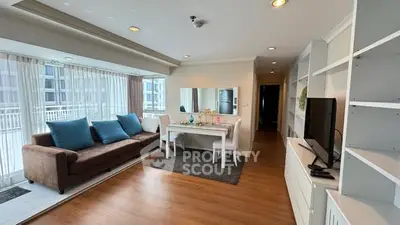 Spacious living room with modern decor and large windows in a high-rise apartment.