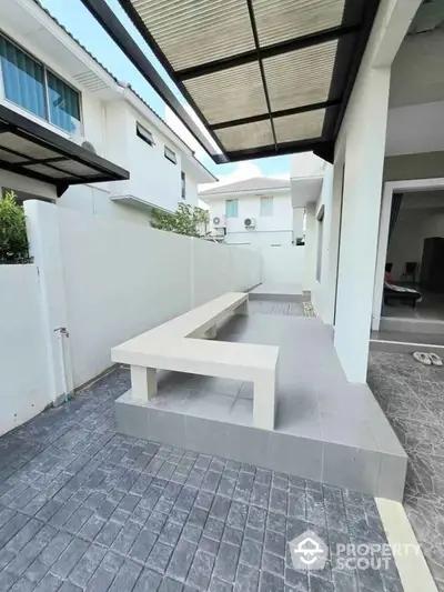 Modern outdoor patio with sleek bench and tiled flooring in contemporary home