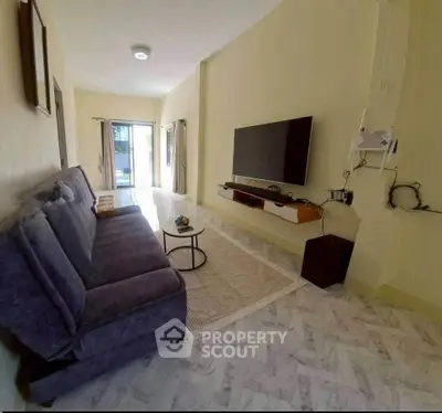 Spacious living room with modern decor and wall-mounted TV, perfect for relaxation and entertainment.
