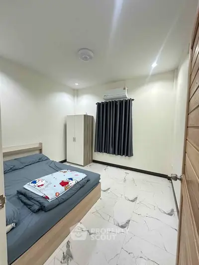 Cozy bedroom with modern decor and air conditioning in a stylish apartment.