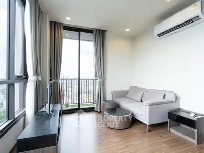 Modern living room with city view, featuring sleek furniture and large windows for natural light.