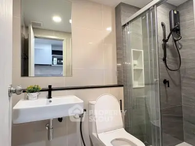 Modern bathroom with sleek shower, elegant sink, and contemporary fixtures in stylish apartment.